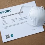 COVID Recovery Certificate on the table and also mask is on the certificate